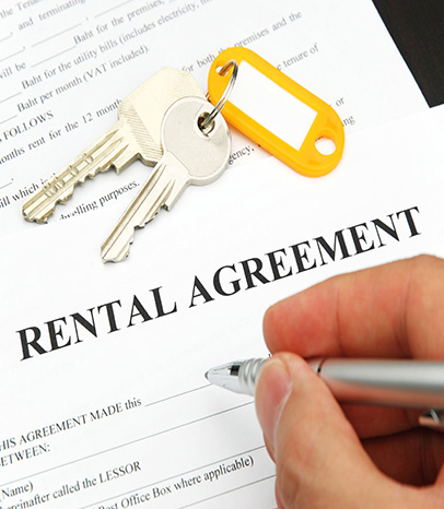 rental agreement form with signing hand and keys and pen